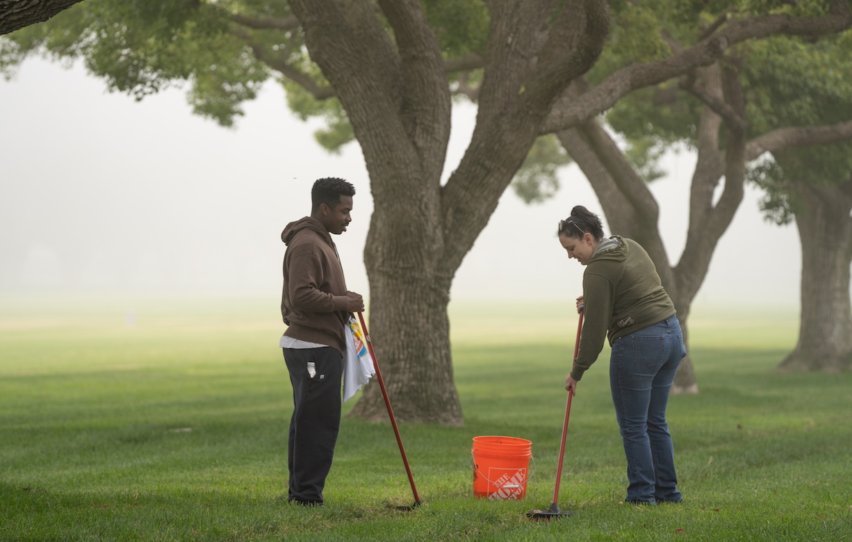 Volunteer Day — Two UCLA volunteers clean veterans’ headstones at the Los Angeles National Cemetery. 