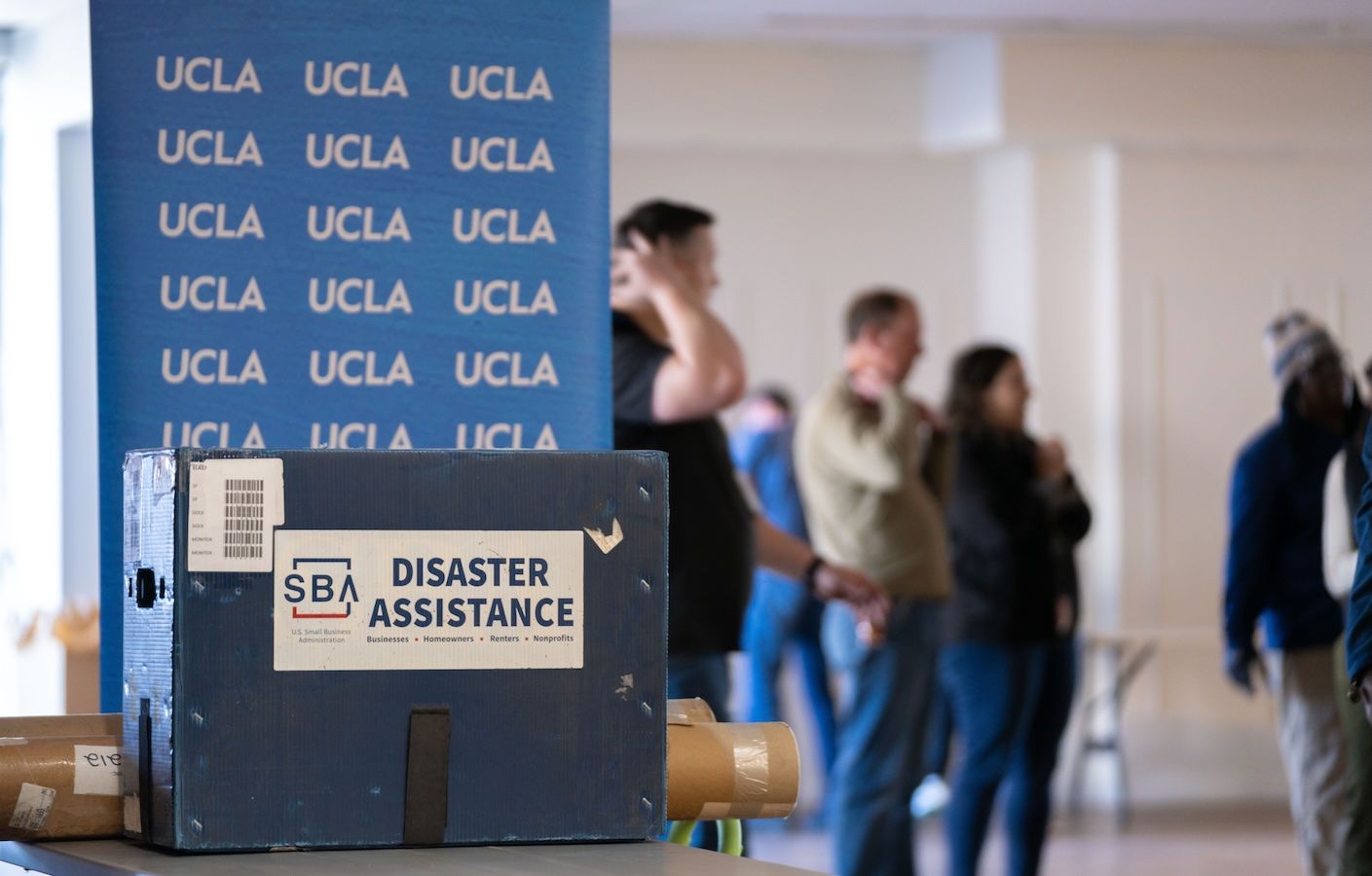 UCLA banner and disaster assistance box with support staff in background