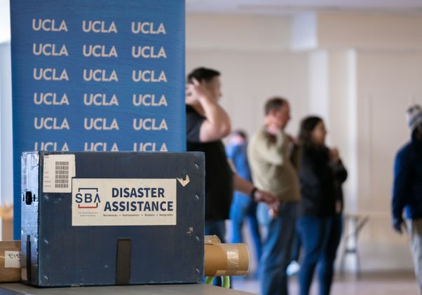 UCLA banner and disaster assistance box with support staff in background