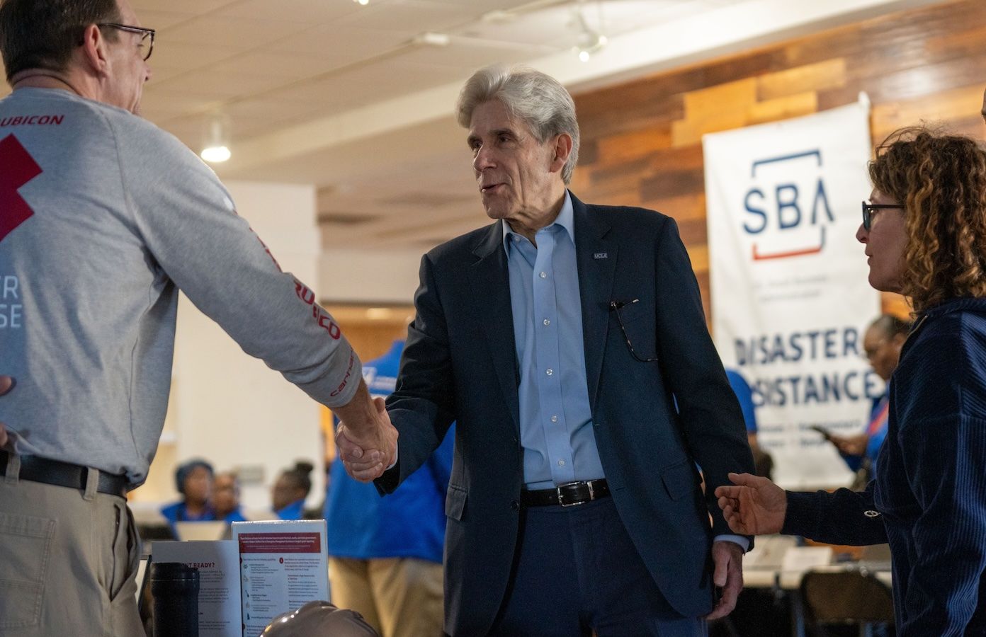 Julio Frenk shaking hands at the disaster recovery center