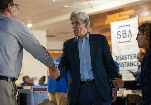 Julio Frenk shaking hands at the disaster recovery center