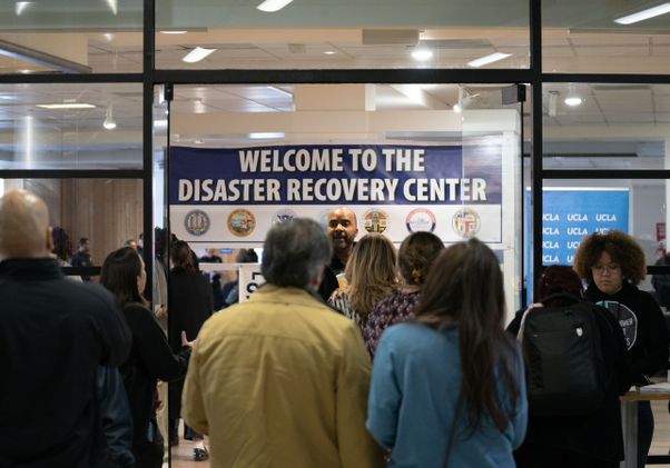 People gathered with inside UCLA Research Park with disaster recovery center sign in background