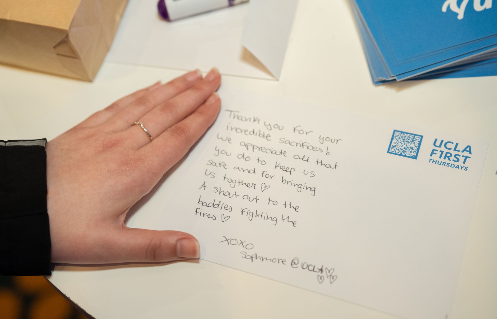 A hand by a handwritten note thanking first responders
