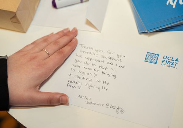 A hand by a handwritten note thanking first responders