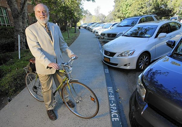 Donald Shoup — on a bicycle near parked cars on the UCLA campus