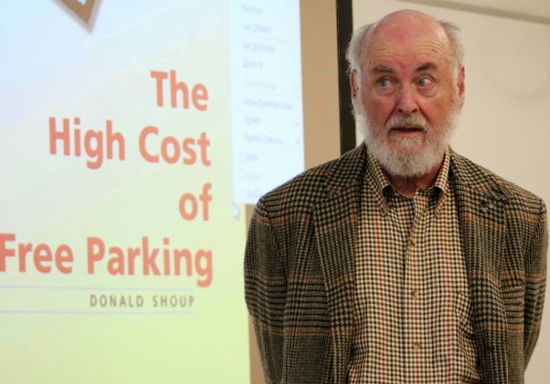 Donald Shoup — standing next to “The High Cost of Free Parking” banner