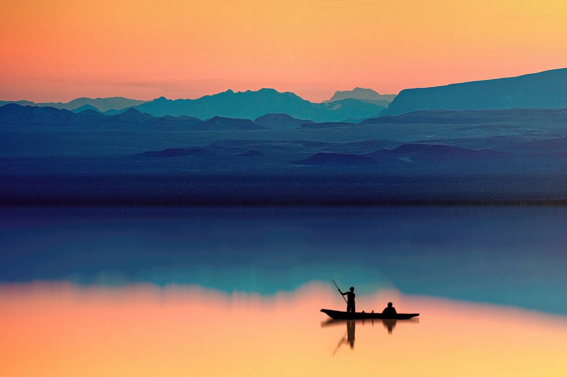 Silhouette of person riding boat