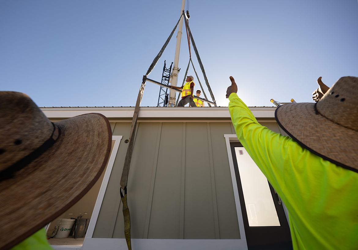 A prehab home is lowered into place.