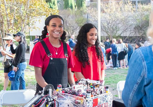 Exploring Your Universe 2025: Two young female volunteers in red shirts