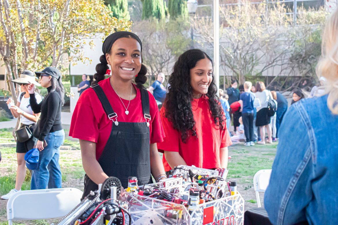 Exploring Your Universe 2025: Two young female volunteers in red shirts