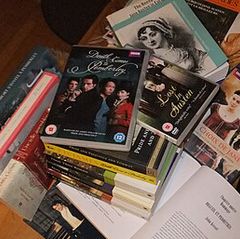 A stack of Jane Austen-related books and DVD sets spread across a surface, including titles such as "Death Comes to Pemberley" and "Lost in Austen."