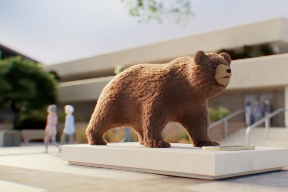 A rendered illustration of a brown bear statue on a white pedestal outdoors, with a modern building and blurred pedestrians in the background.