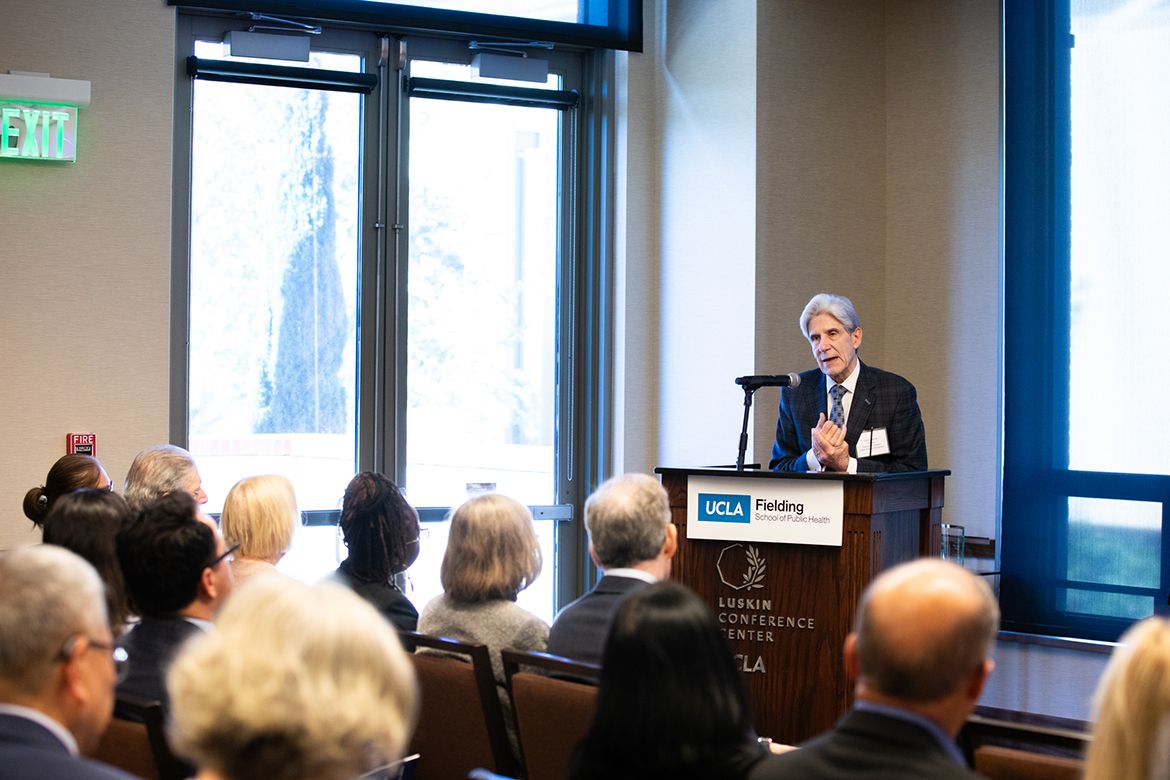 UCLA Chancellor Julio Frenk speaks at a UCLA Fielding School of Public Health podium at the Luskin Conference Center, addressing a seated audience.