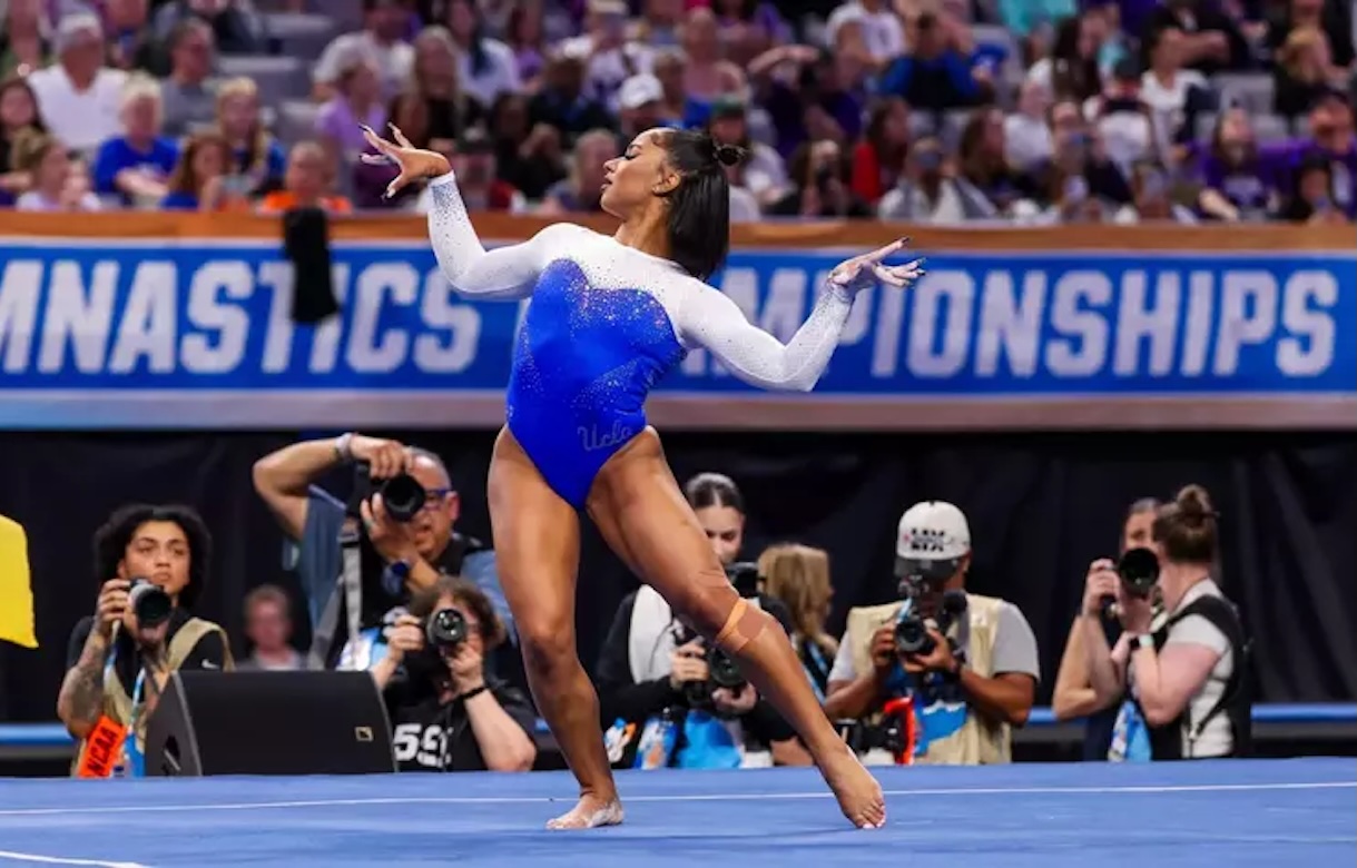 Jordan Chiles performs a floor exercise routine at the NCAA championship tournament, captured mid-movement in front of a crowded arena.