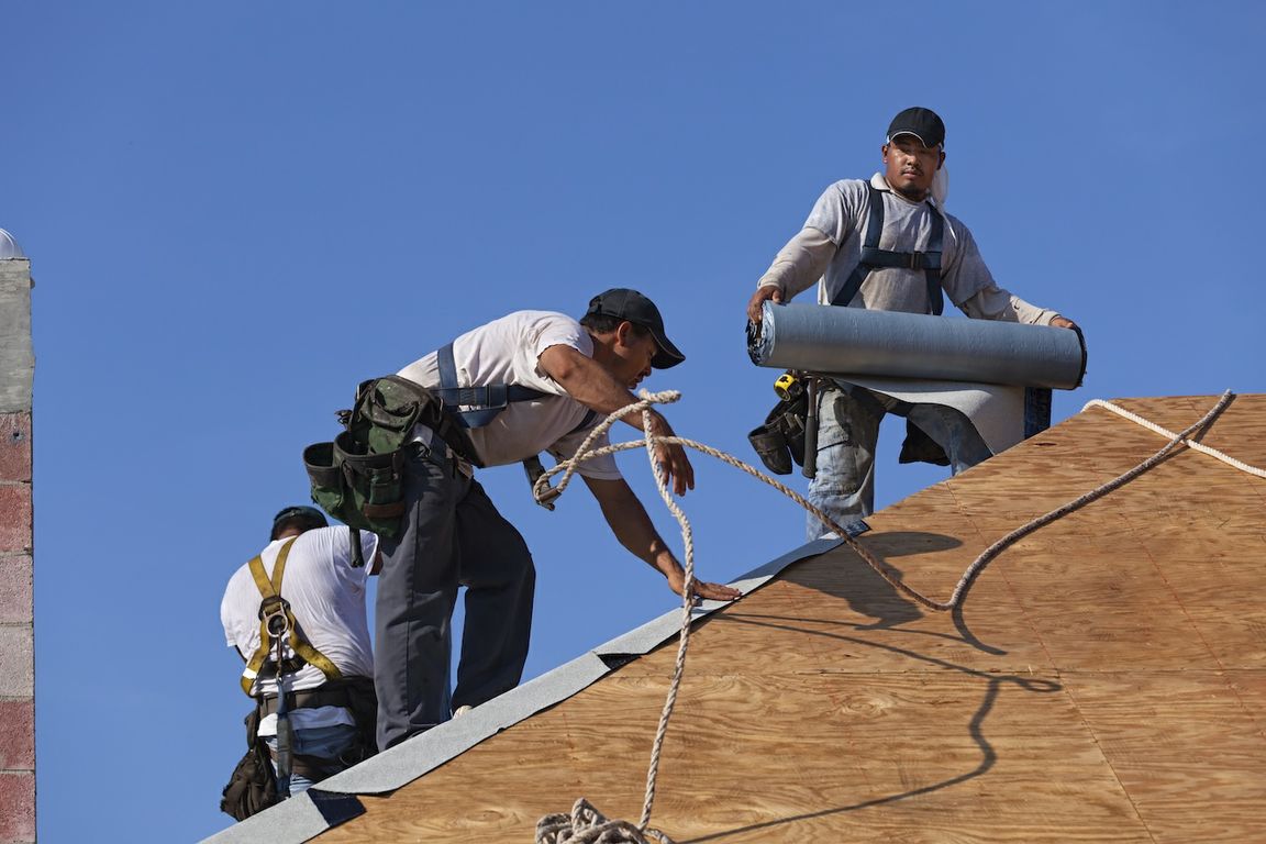 Three men installing a new roof
