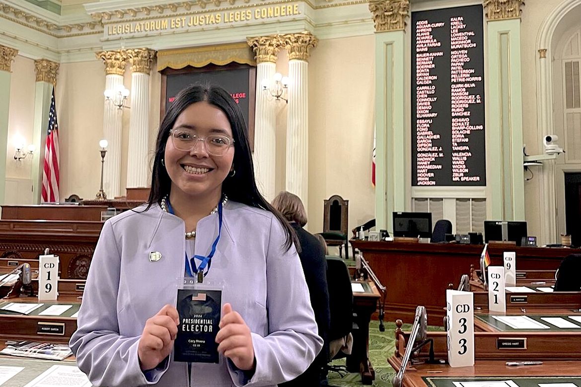 Cecy Rivera, in lavender jacket, holds a 2024 Presidential Elector badge