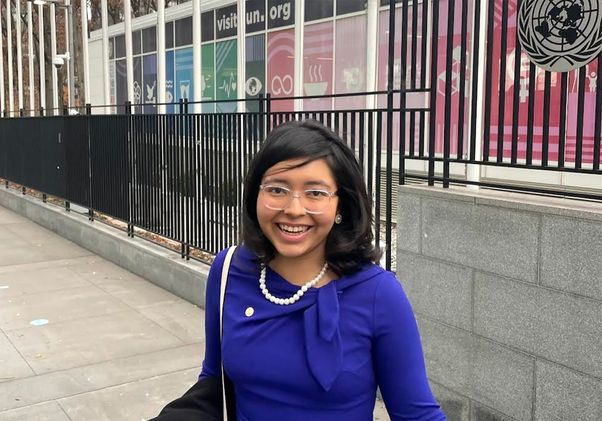 Cecy Rivera, in blue top and pearls, in front of the United Nations building