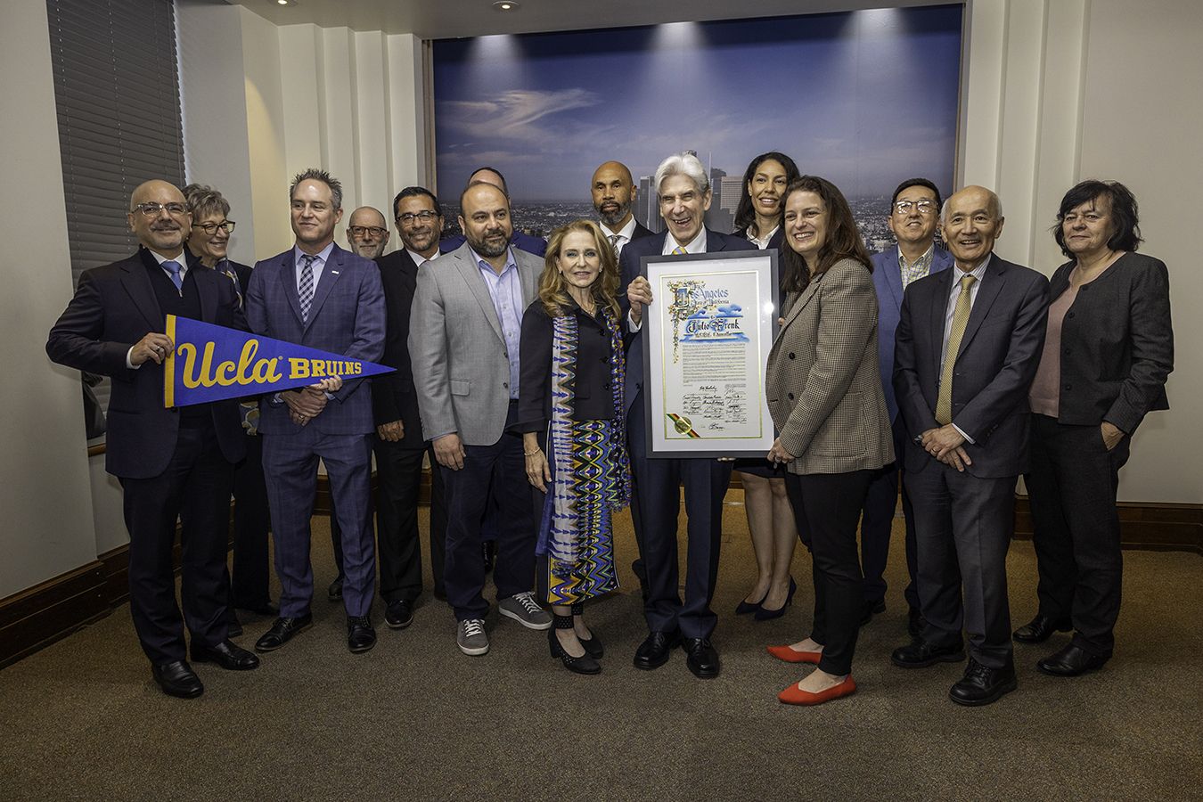 Julio Frenk, surrounded by UCLA leaders, holds up a proclamation welcoming him from the City Council
