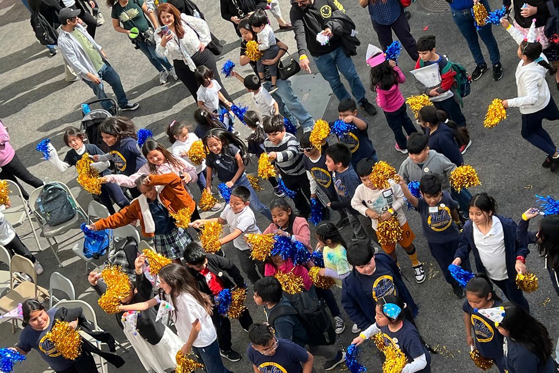 Overhead view of students holding blue and gold pompoms on playground