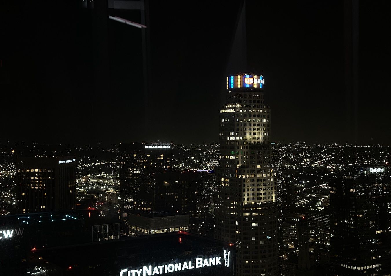 Wide shot of the top of the U.S. Bank Tower in downtown Los Angeles lit up in blue and gold