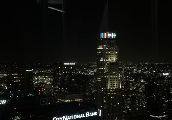 Wide shot of the top of the U.S. Bank Tower in downtown Los Angeles lit up in blue and gold