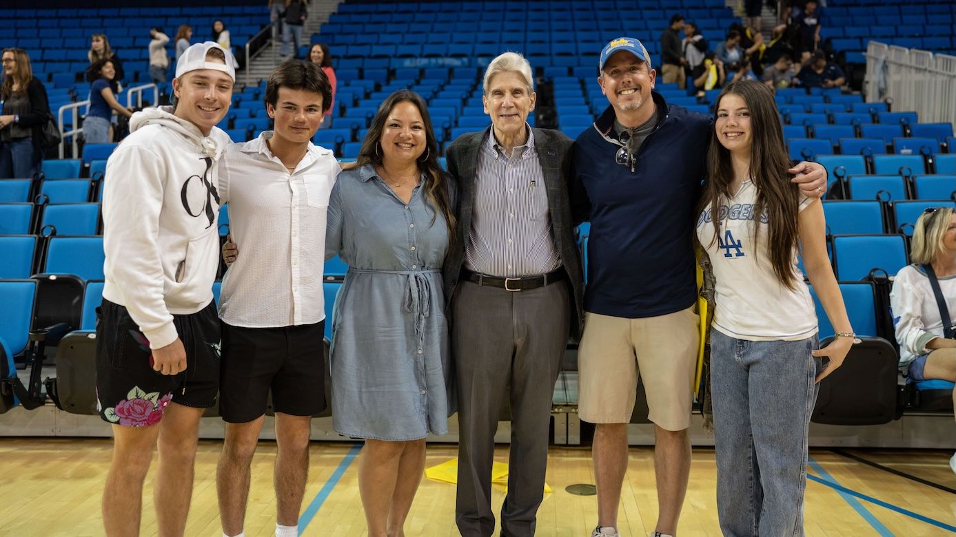 Bruin Day–Chancellor Julio Frenk (third from right) posing in family with students and parents in Pauley Pavilion