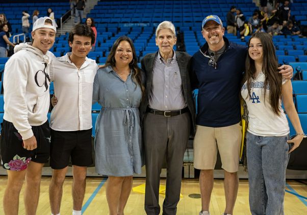 Bruin Day–Chancellor Julio Frenk (third from right) posing in family with students and parents in Pauley Pavilion
