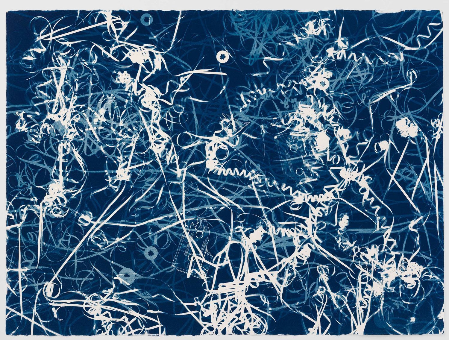Thin curly pieces of white paper against a blue background