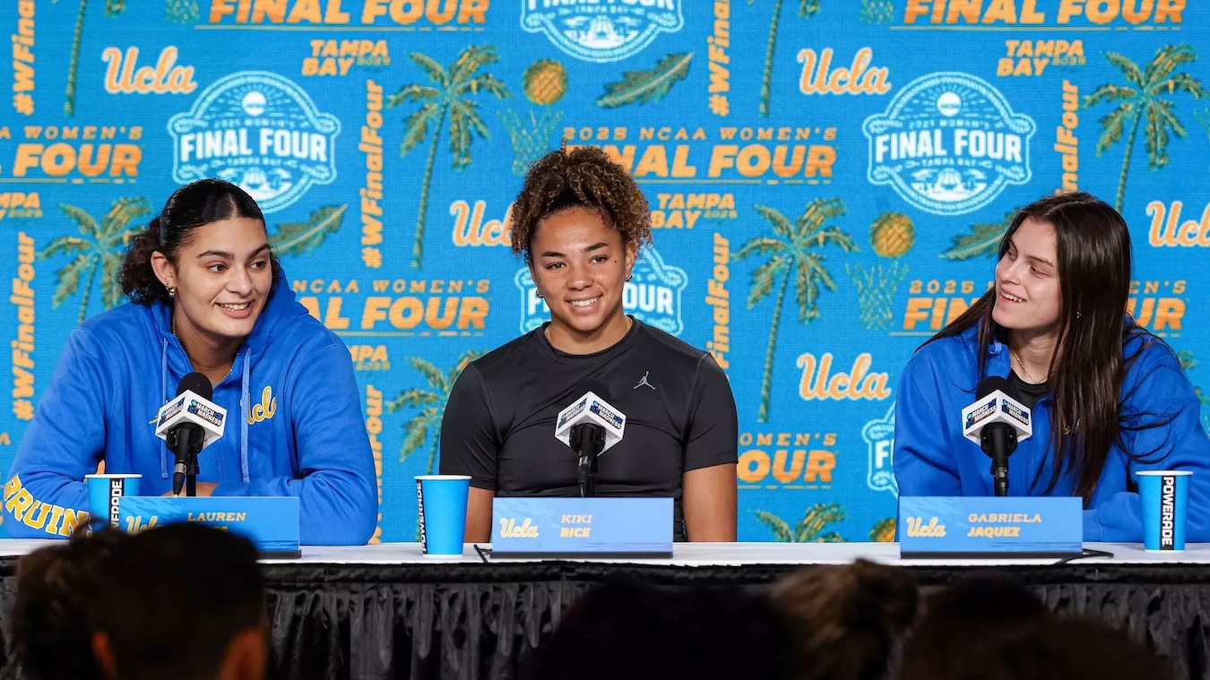 Bruin players Lauren Betts, Kiki Rice and Gabriela Jaquez sit behind microphones at table at the Final Four press conference.
