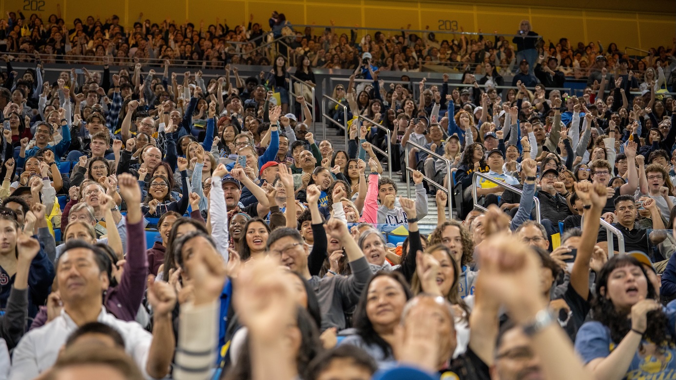 Bruin Day–Wide shot of crowd in Pauley Pavilion raising their hands