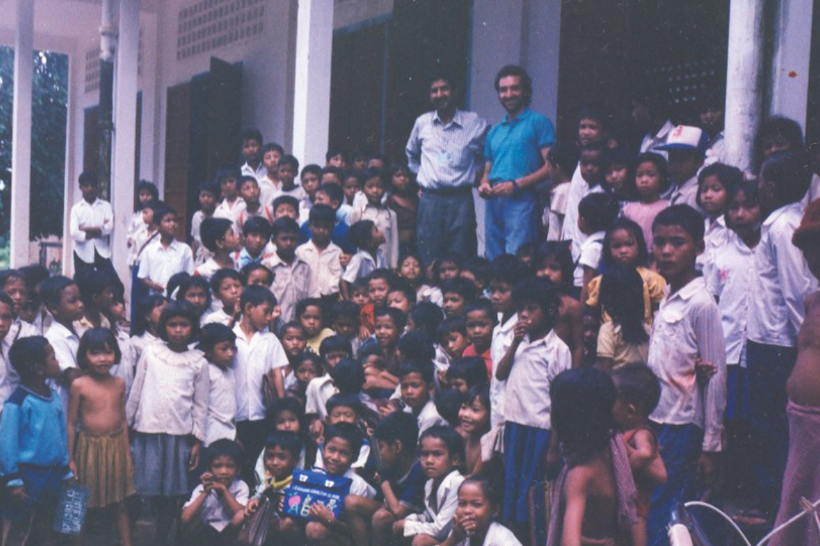 Patrick Heuveline stands with a group of kids during his time on a peacekeeping mission in Cambodia in 1991–92.