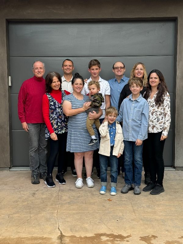 Robert Reiss, far left in back row, wears a red top and black jeans for a group photo