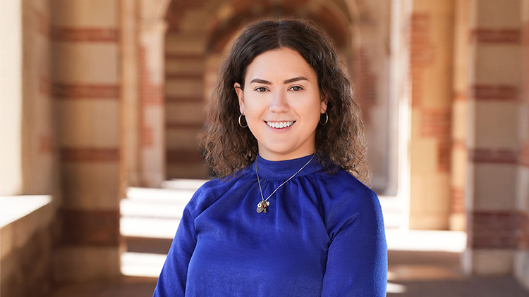 Head-and-shoulders image of Vanessa Aviva González-Siegel standing in front of building arches