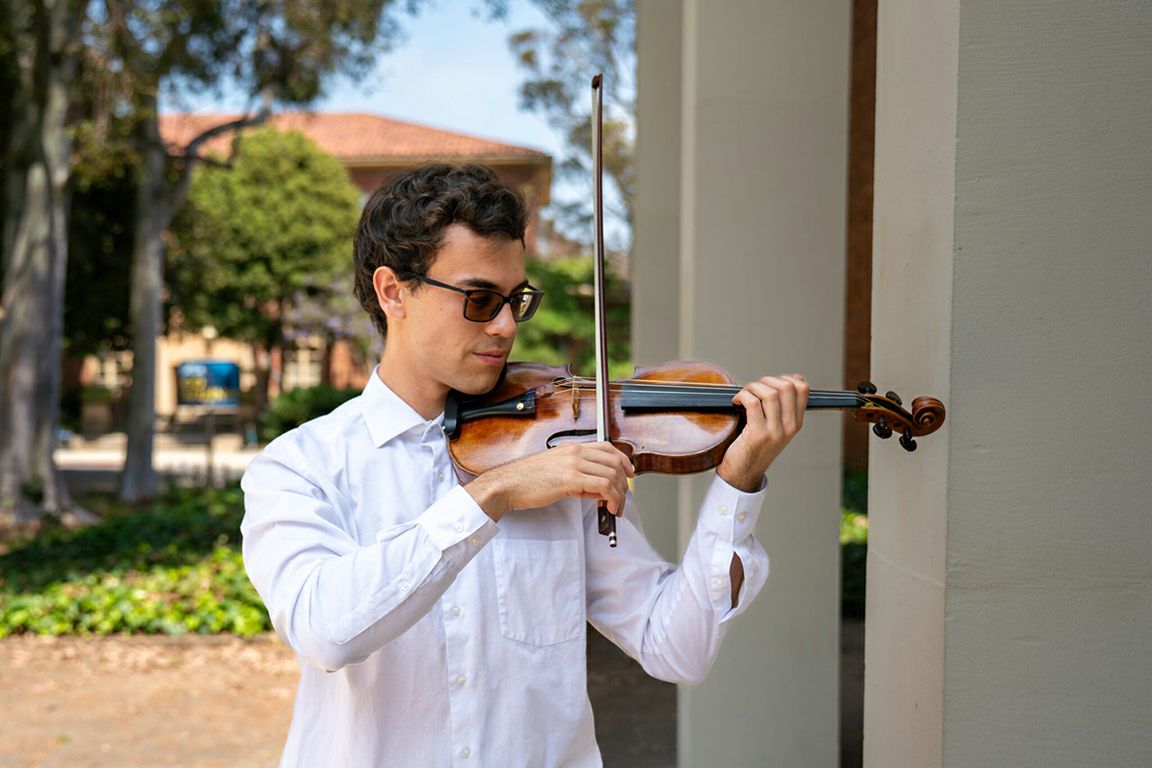 Gabriel Esperon playing a violin outdoors