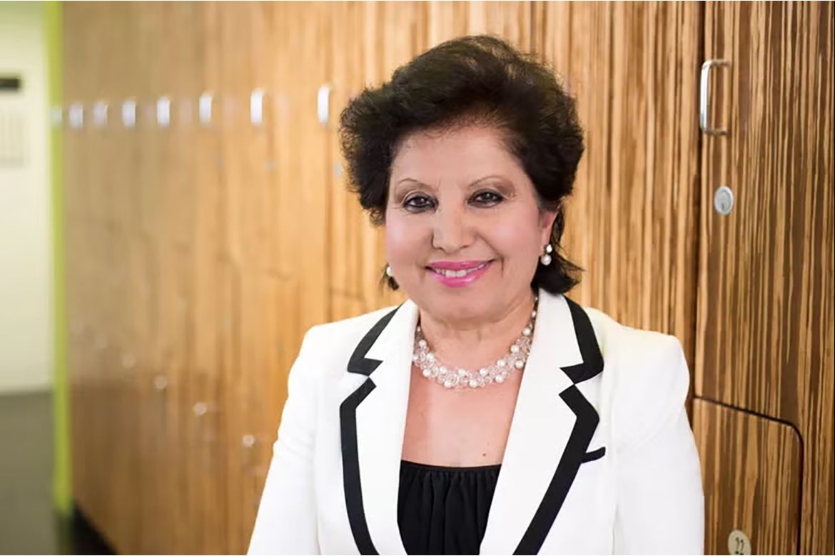 Anahid Jewett, in black top, white-and-black jacket and pearl necklace