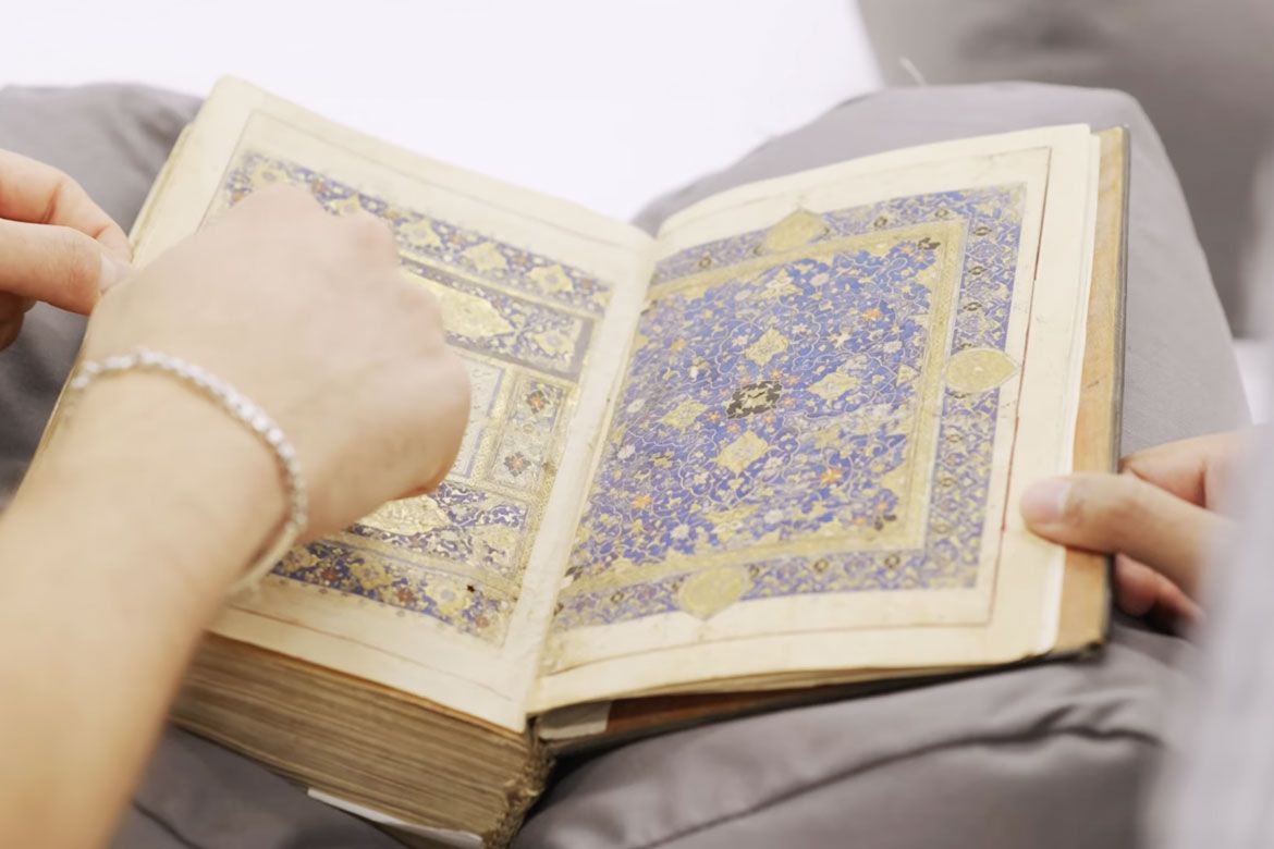 Hands touch an Islamicate manuscript