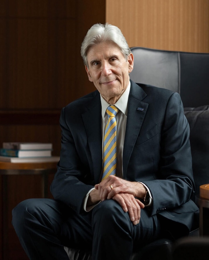Julio Frenk seated in dark suit and blue-and-gold tie