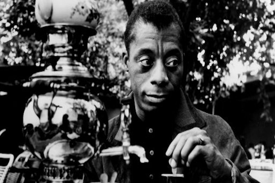 Black-and-white image of James Baldwin at tea