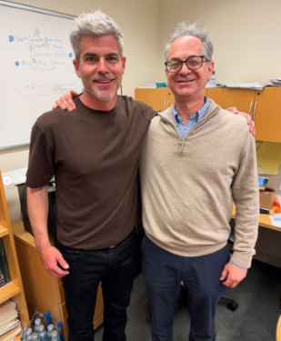 Jeffrey Randall Allen and Dr. Gerald Lipshutz with arms around their shoulders in front of desk in Lipshutz's office