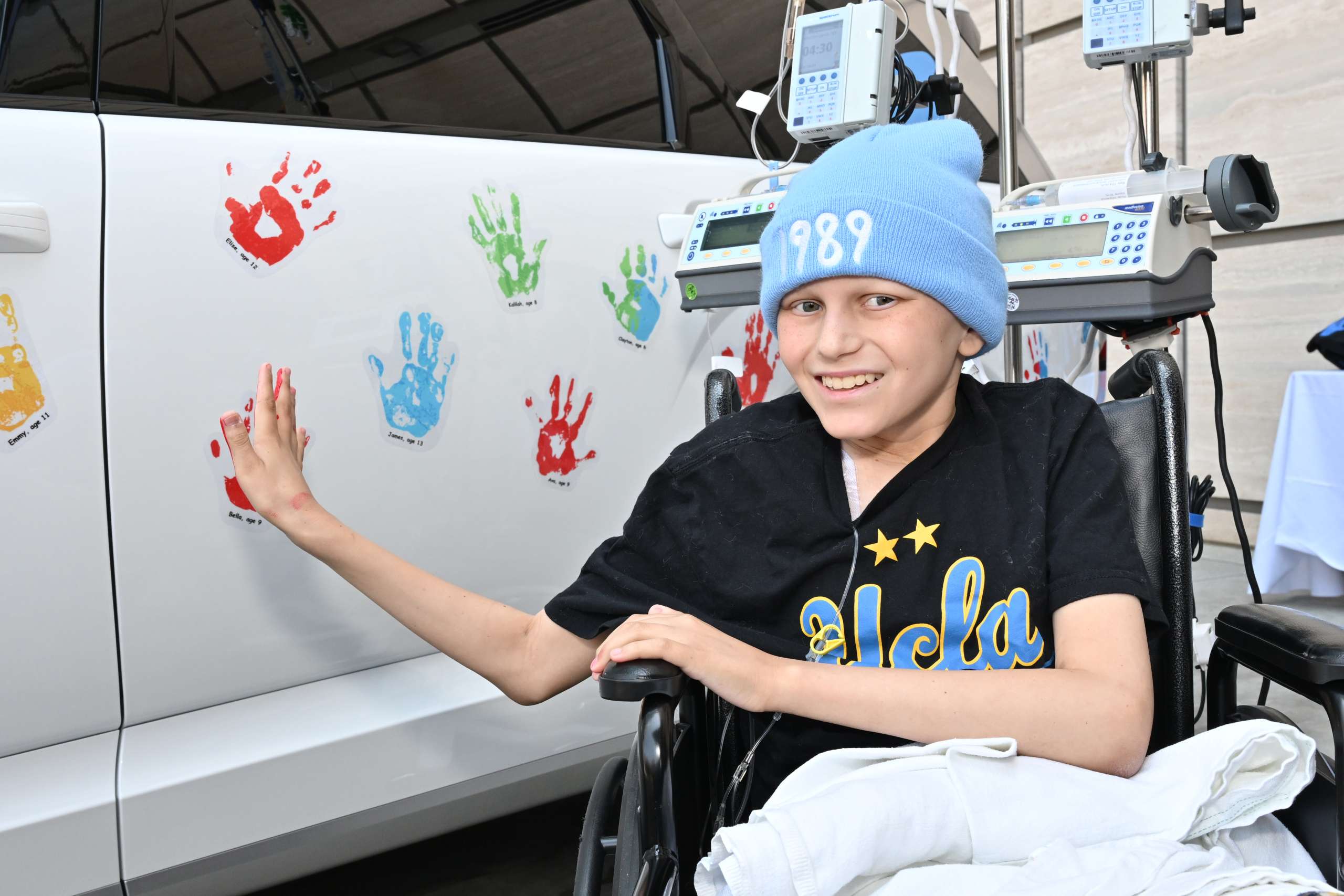 Young UCLA Health cancer patient Jake Brandes places a painted handprint on the 2025 Hyundai vehicle at the Aug. 5 ceremony, symbolizing hope and progress in the fight against childhood cancer.