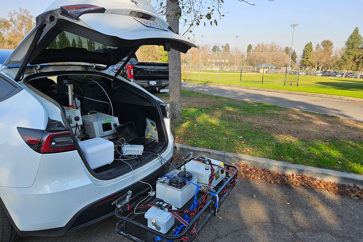 Mobile air sampling equipment in a car white car with the trunk open and gear on a trolly at the back following the wildfires in Los Angeles