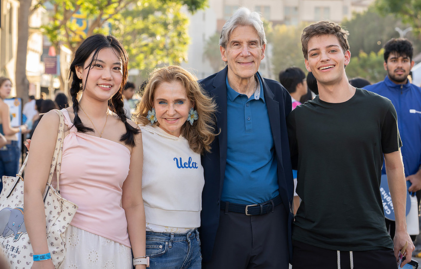 Chancellor Julio Frenk and Felicia Knaul smile with UCLA students at the Westwood Village Block Party.