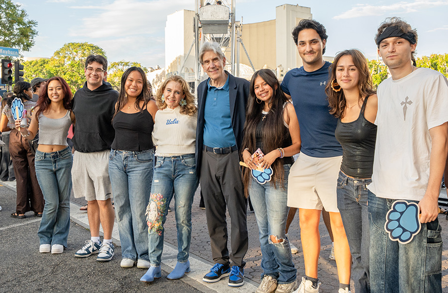 Chancellor Julio Frenk and Felicia Knaul smile as they stand with a group of students  