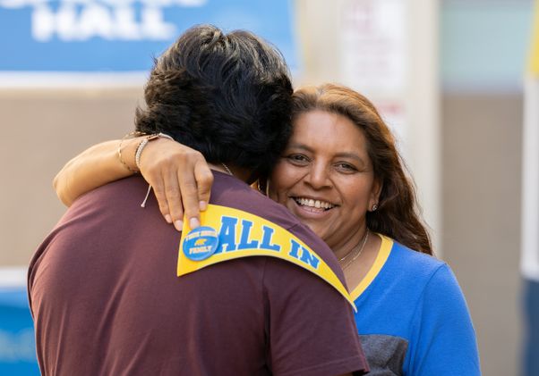 Move-in: Mother hugs son while holding UCLA "All In" penant