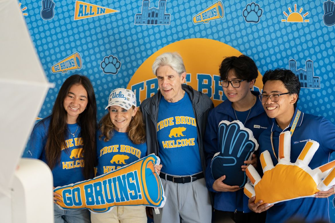Move-in—Julio Frenk and Felicia Knaul with 3 students in front of True Bruin sign