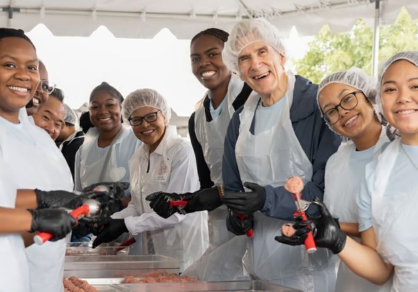 Chancellor Frenk, Mayor Bass and students making meatballs