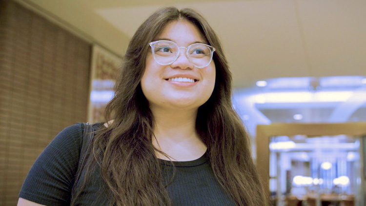 A head-and-shoulders photo of Evelyn Giron in black top and glasses