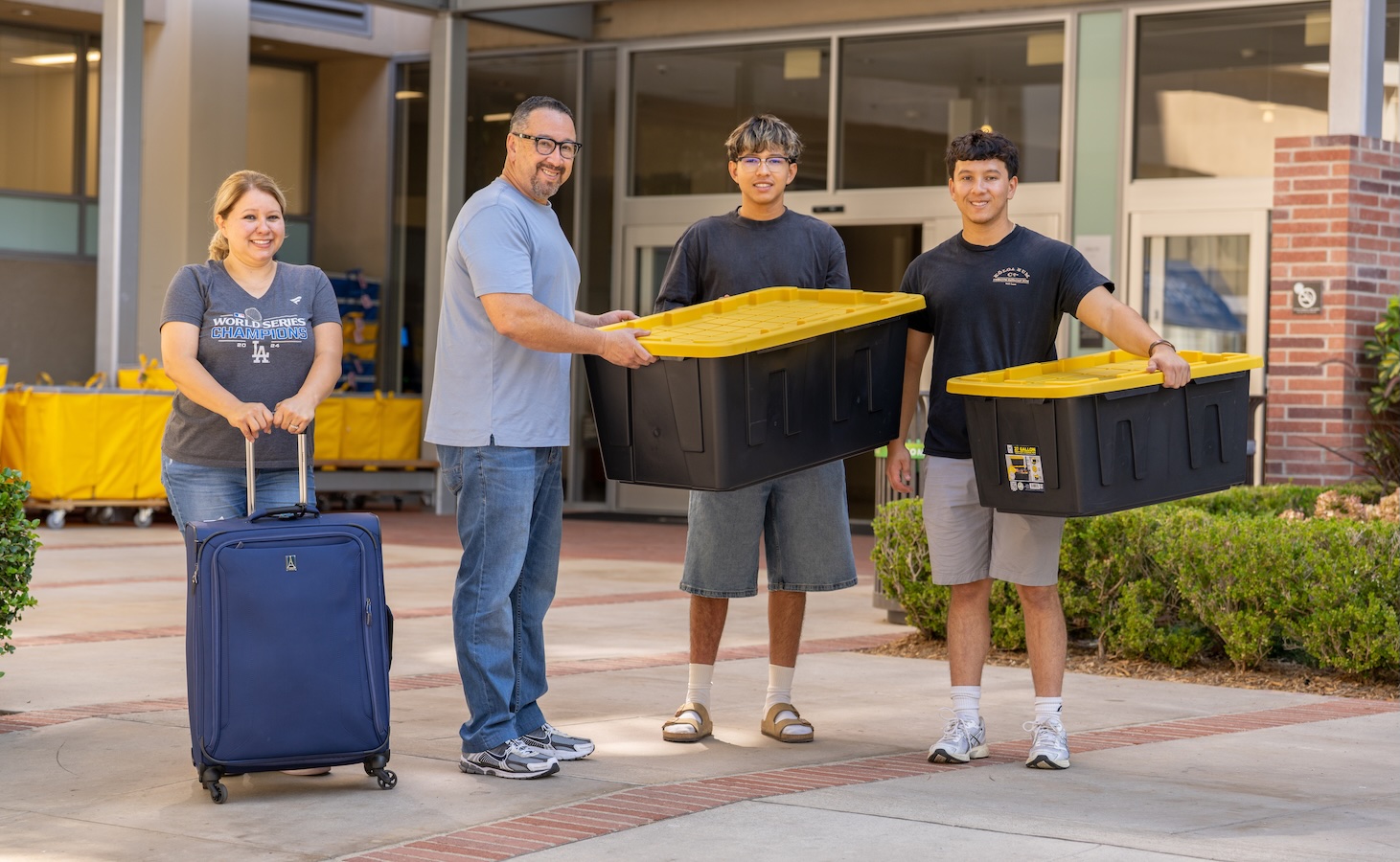Move-in: Students and parents with suitcase and black moving bins