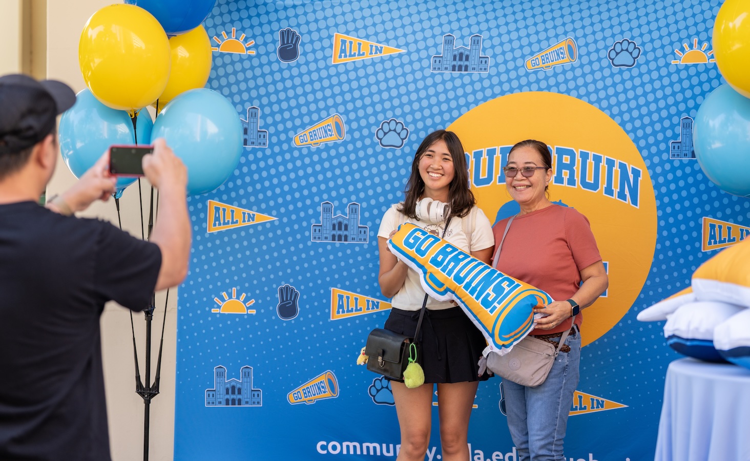 Move-in: Student and mother have photo taken in front of Bruin backdrop