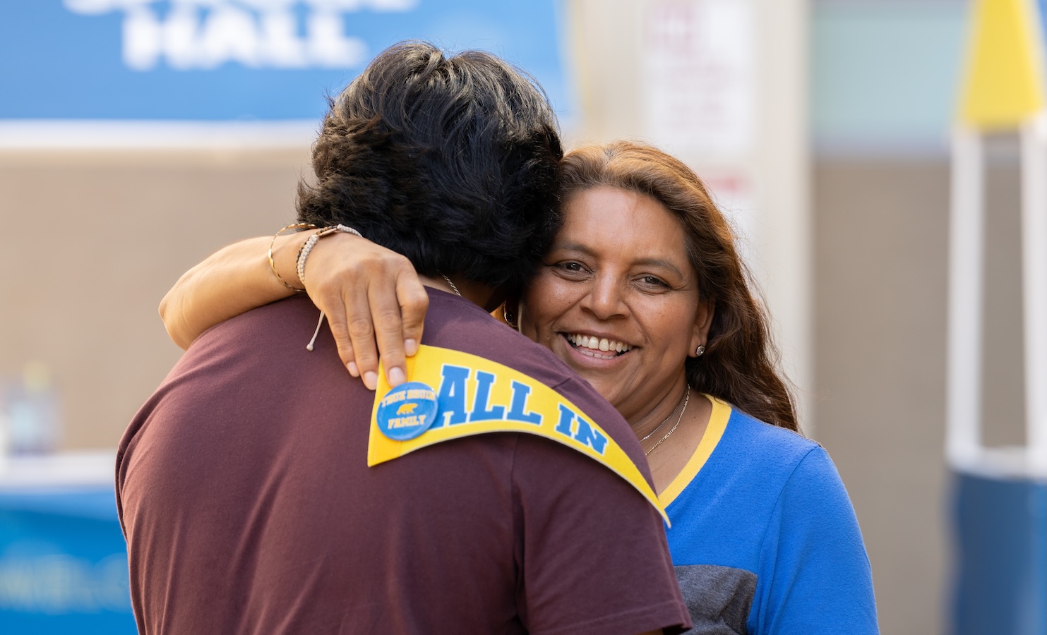 Move-in: Mother hugs son while holding UCLA "All In" penant